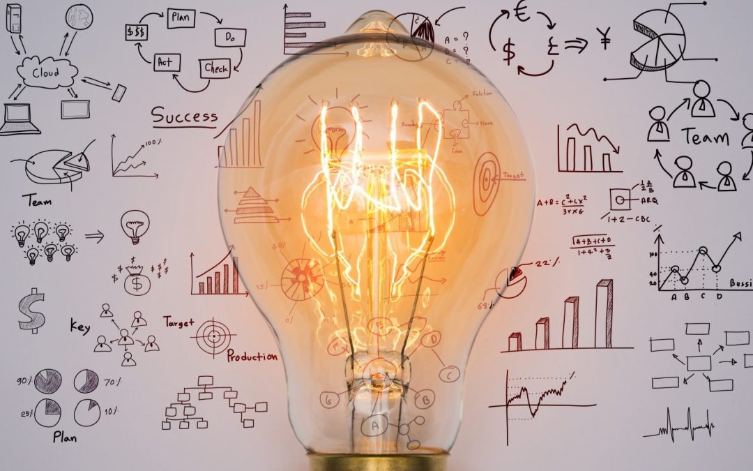 Lightbulb idea in front of work plans and graphs